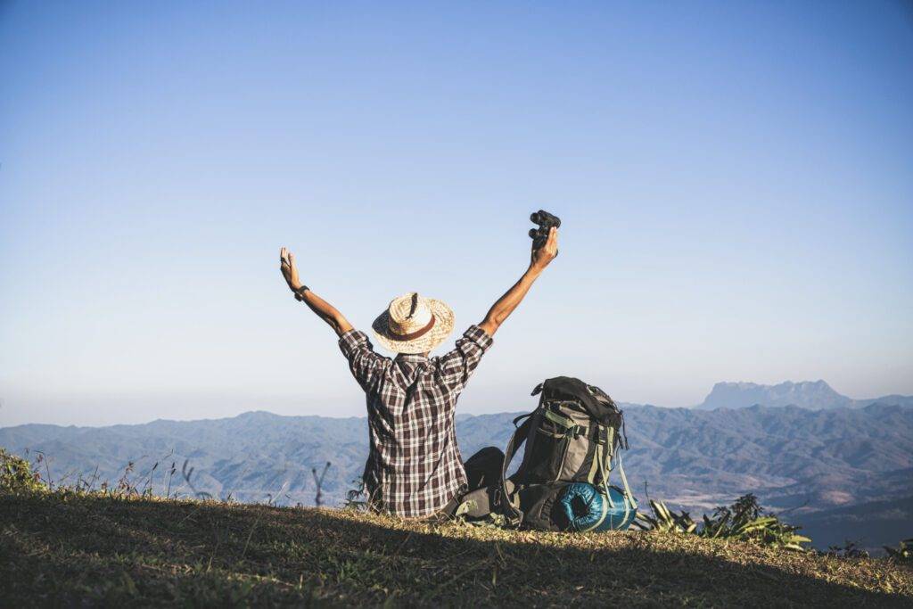 tourist-from-mountain-top-sun-rays-man-wear-big-backpack-against-sun-light